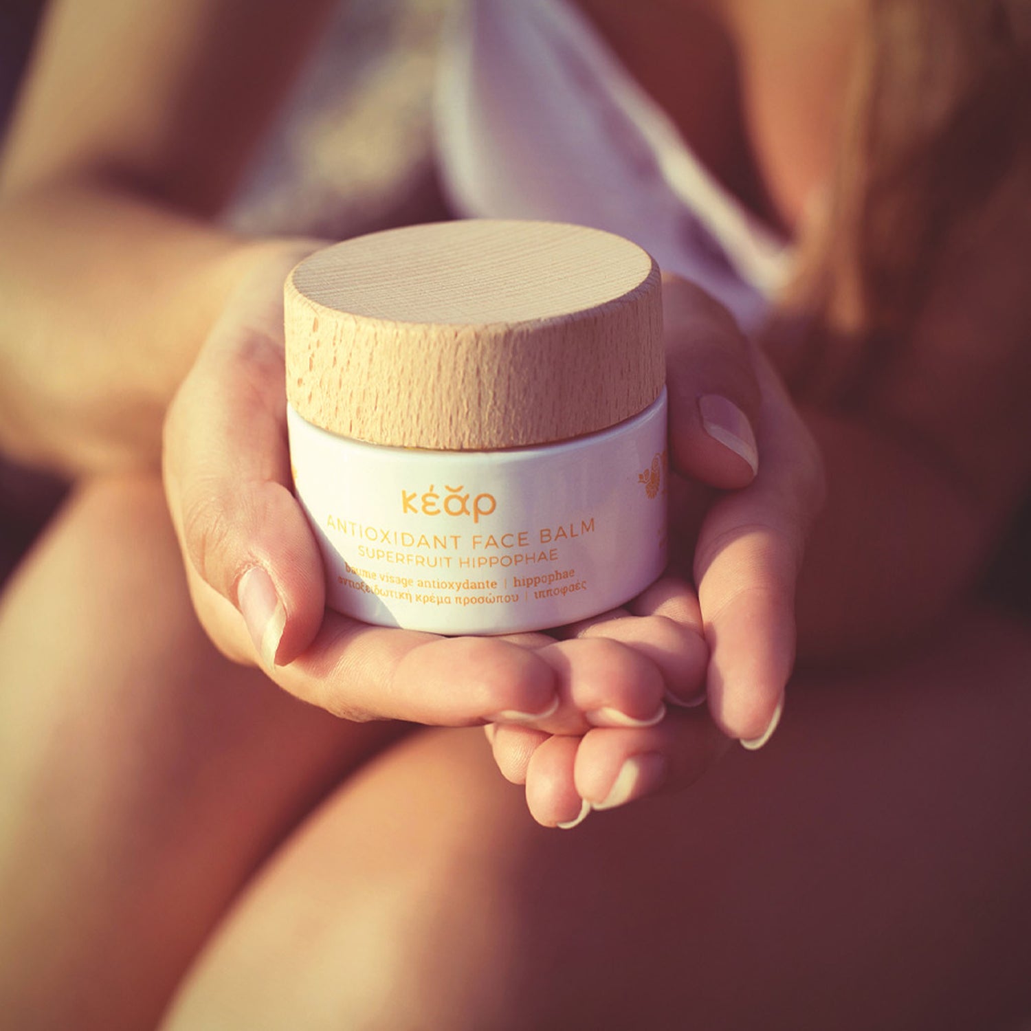 Hands holding a jar of Kear waterless AntiOxidant face balm with seabuckthorn superfood.