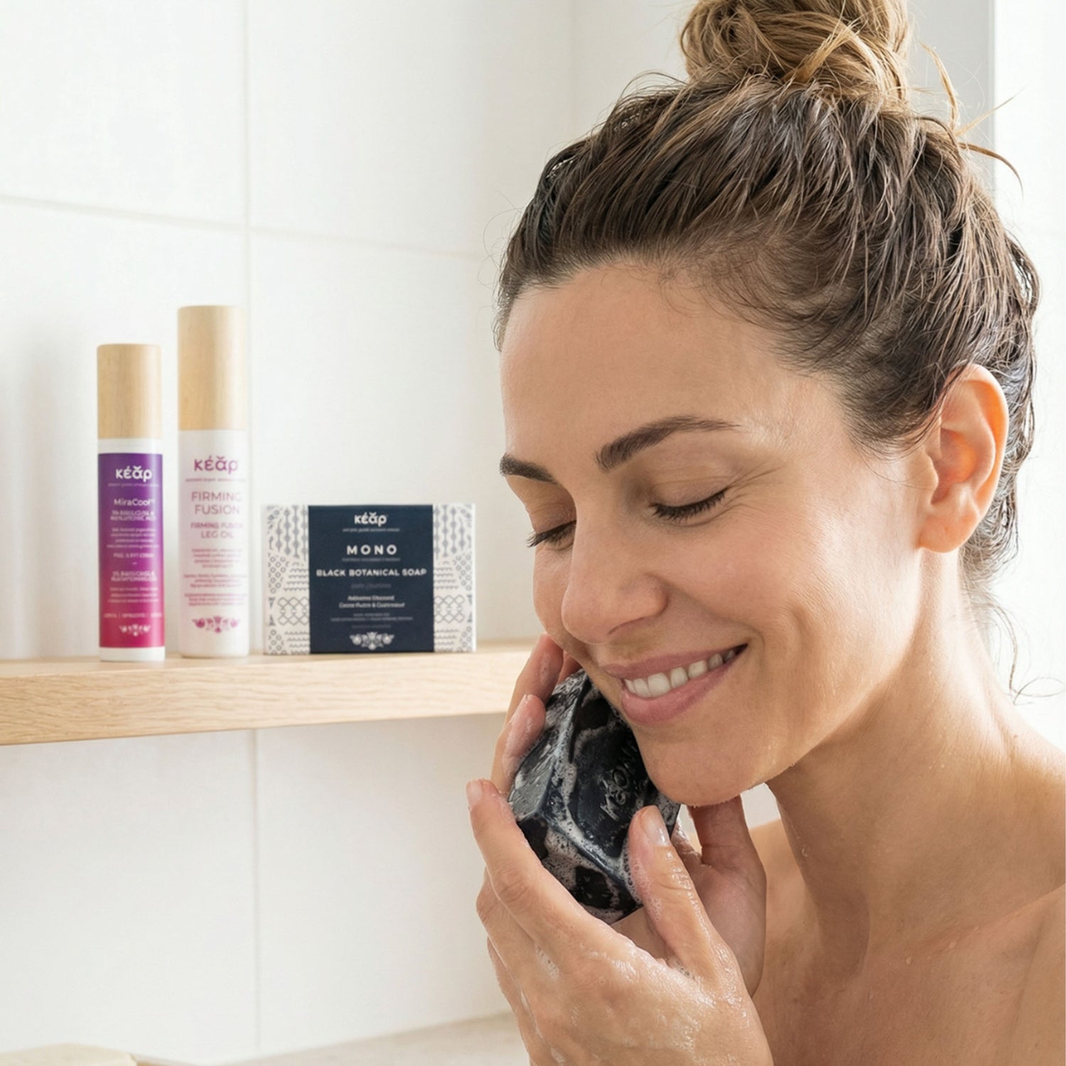 Woman cleansing face with Kear MONO Black botanical soap with activated charcoal.