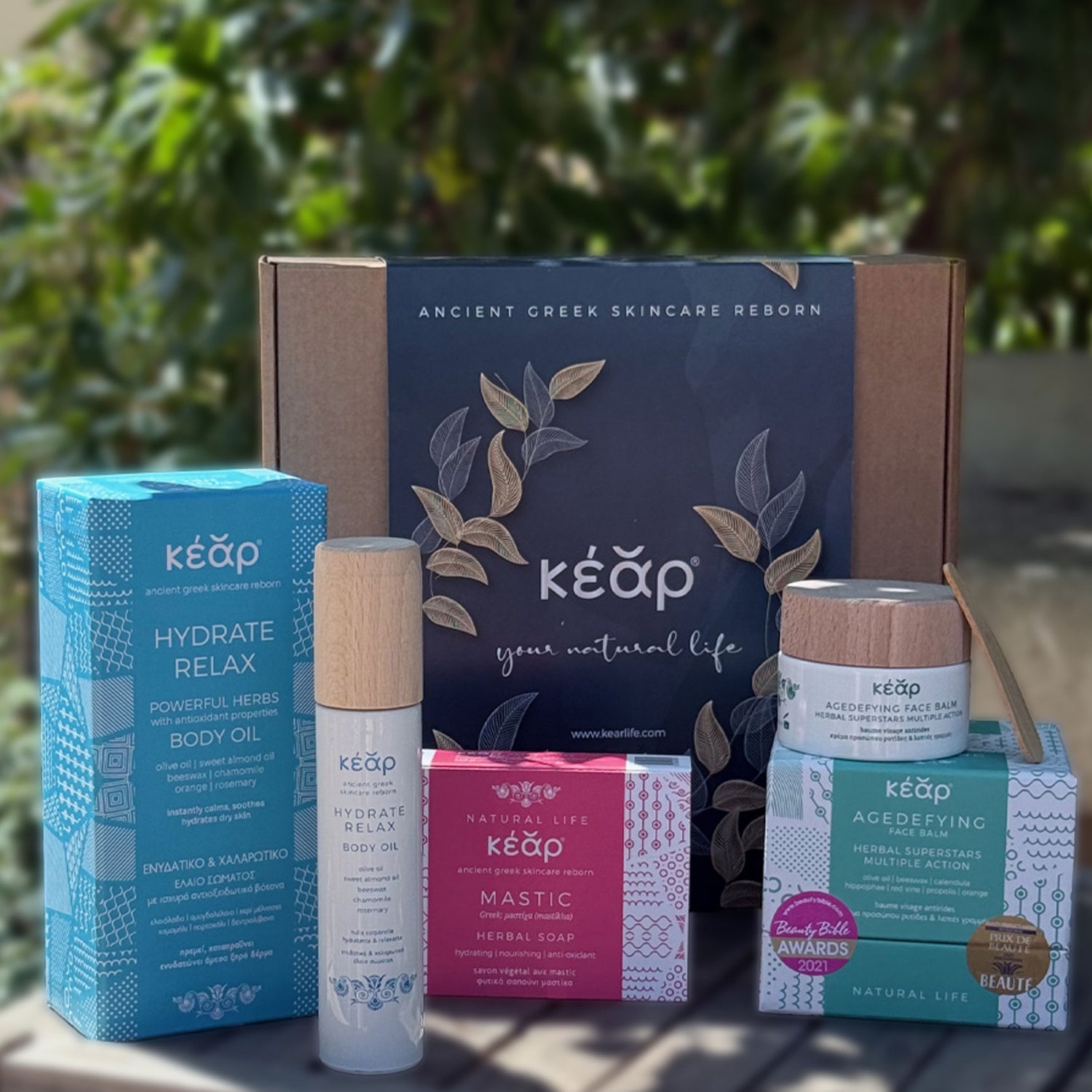 Closeup of Kear natural skincare face and body set with Agedefying face balm, Hydrate Relax Body Oil and Mastic Herbal Soap.