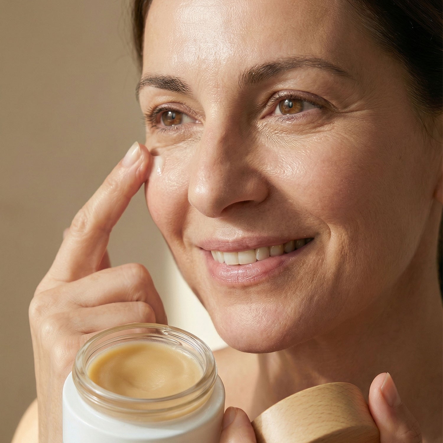 Woman applying Kear waterless multiple action natural AgeDefying face balm for wrinkles and fine lines.