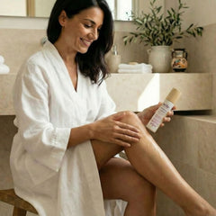 Woman applying Kear Firming Fusion waterless oil on legs.