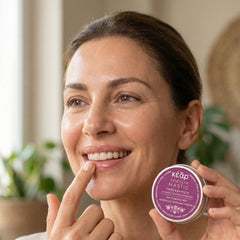 Woman applying Kear SofiLip mastic natural lip balm.