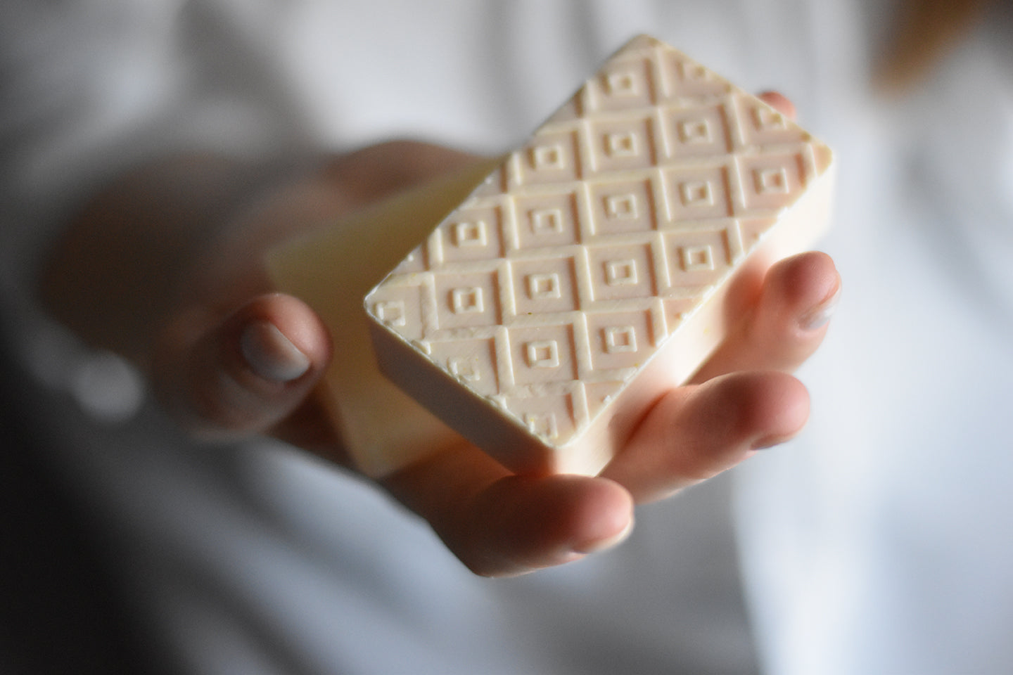 Hand holding Kear herbal soaps