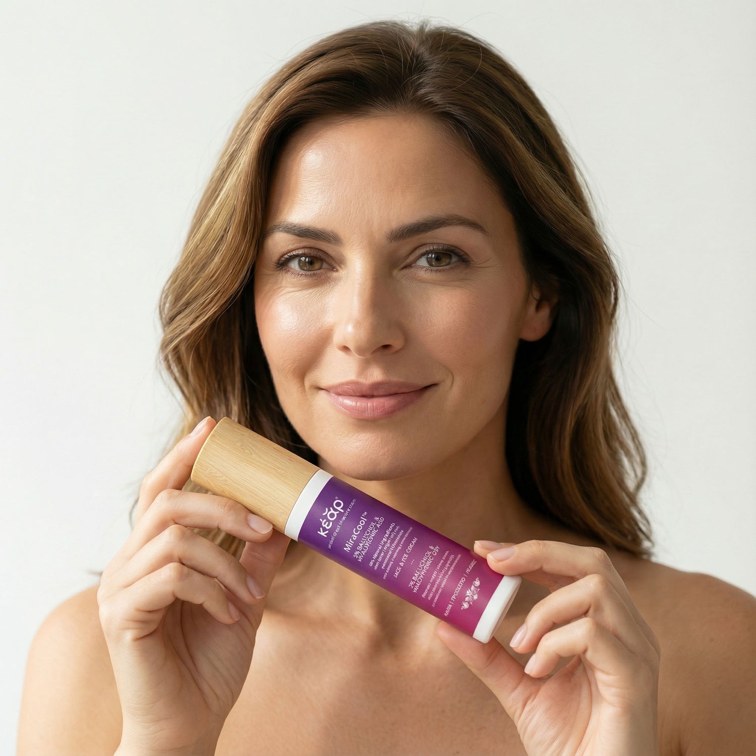 Woman holding Kear MiraCool Face, Eyes cream with bakuchiol, aloe and hyaluronic acid.