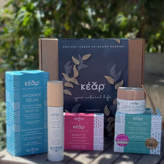Closeup of Kear natural skincare face and body set with Agedefying face balm, Hydrate Relax Body Oil and Mastic Herbal Soap.